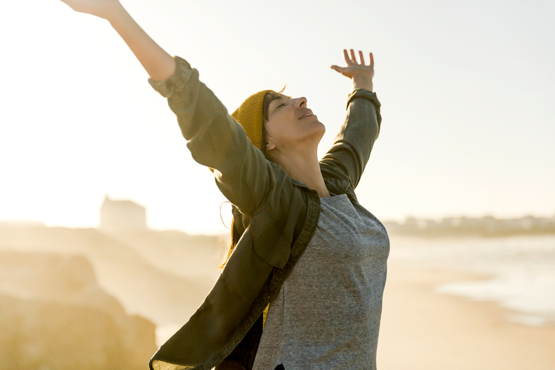 Energetic Woman with Raised arms Outdoors